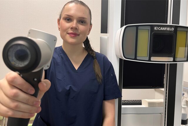 Diplom-Kosmetikerin Rabea Wien in der Hautarztpraxis von Dr. Nima Nasserani in Kamen. Sie zeigt einen Handscanner, den sie bei der KI-unterstützten Hautkrebsvorsorge einsetzt.