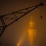 Ein Hafenkran umgeben von dichtem Nebel.