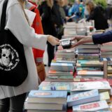 Passanten stöbern auf der Straße an einem Stand in Büchern