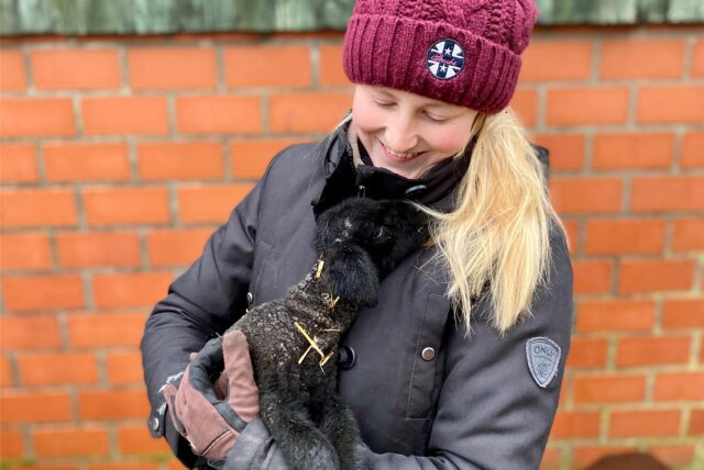 Nadine Stockhofe hält ein schwarzes Lamm im Arm