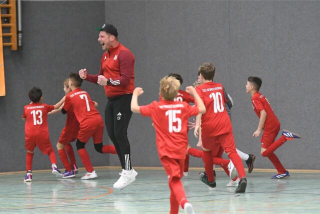 Die E-Jugend des TuS Henrichenburg feiert mit Coach Carsten Ferlmann.
