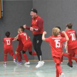 Die E-Jugend des TuS Henrichenburg feiert mit Coach Carsten Ferlmann.