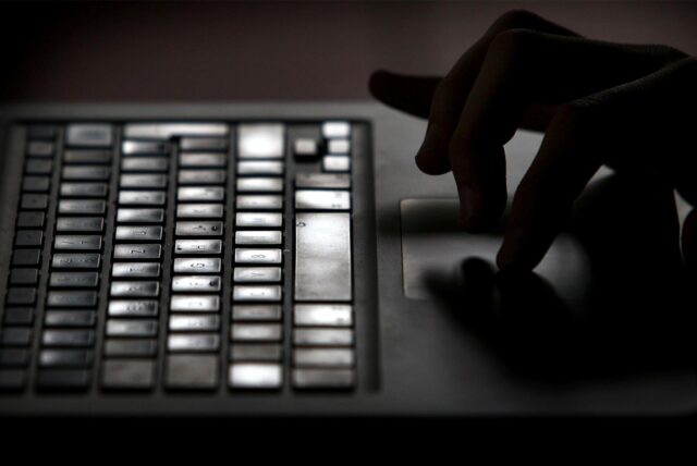 Eine Hand tippt auf einer Tastatur.