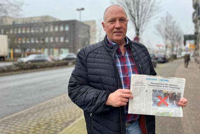 Klaus Peeters steht mit einer Dorstener Zeitung in der Hand an der Julius-Ambrunn-Straße in Dorsten.