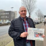 Klaus Peeters steht mit einer Dorstener Zeitung in der Hand an der Julius-Ambrunn-Straße in Dorsten.
