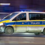 Das Bild zeigt ein komplettes Polizeiauto, das schnell die Straße entlang fährt.