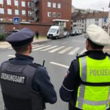 Ein Polizist und ein Mitarbeiter des Ordnungsamtes vor dem Drogenkonsumraum in Dortmund