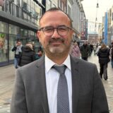 Emre Güleç steht auf dem Dortmunder Westenhellweg und schaut in die Kamera.