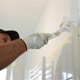 Ein Handwerker streicht ein Rohr