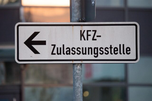 Ein Verkehrsschild, das den Weg zu einer Kfz-Zustellungsstelle weist.
