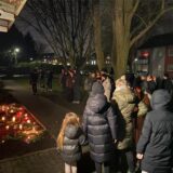 Mehrere Menschen versammeln sich vor der Wohnung, in der eine 32-jährige Dortmunderin mutmaßlich von ihrem Ex-Partner ermordet worden ist. Kerzen sind vor dem Haus aufgestellt.