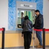 Zwei Menschen stehen an einem Kassenschalter.
