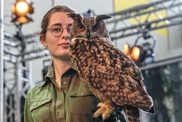 Eine Frau mit einer Eule auf dem Arm bei der Messe Jagd und Hund in Dortmund