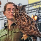 Eine Frau mit einer Eule auf dem Arm bei der Messe Jagd und Hund in Dortmund
