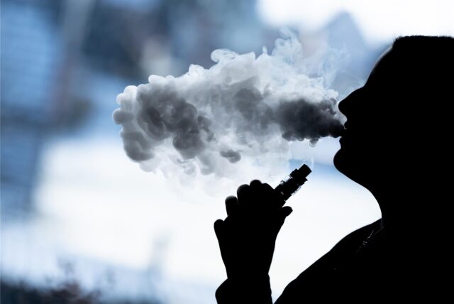 Eine Frau raucht eine E-Shisha
