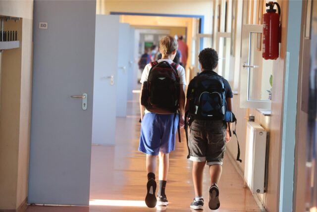 Schüler gehen zum Unterricht einen Gang entlang