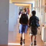 Schüler gehen zum Unterricht einen Gang entlang