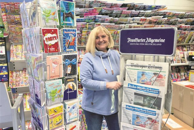 Verkäuferin Karin Harbich neben den Grußkarten- und Zeitungsständern.
