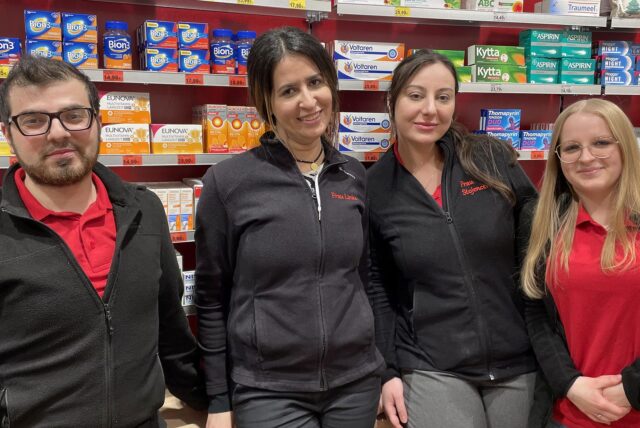 Die Dortmunder Apothekerin Wafaa Choukrane steht mit drei Beschäftigten vor einem Regal mit Medikamenten.