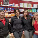 Die Dortmunder Apothekerin Wafaa Choukrane steht mit drei Beschäftigten vor einem Regal mit Medikamenten.