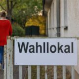 Eine Wahlhelferin läuft in ein Wahllokal.