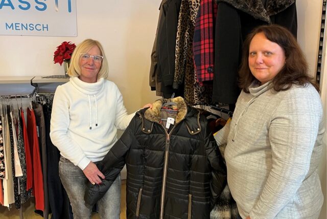Gabriele van der Poel und Annette Schimanski halten im Second-Hand-Geschäft einen Mantel in den Händen.