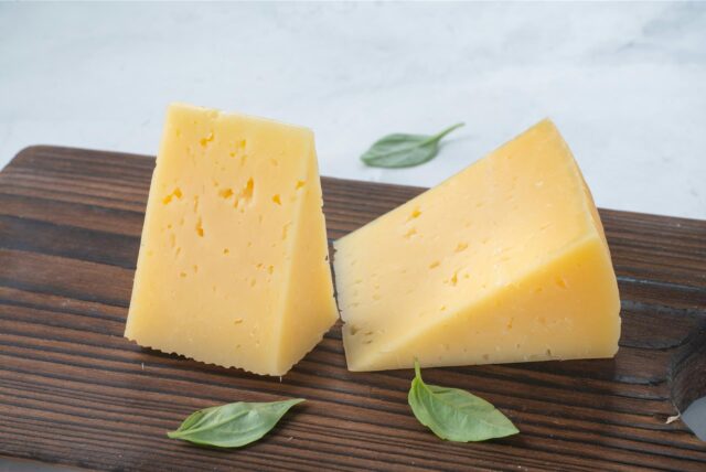 Zwei Stücke Käse auf einem Brett.
