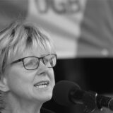 Ein Schwarz-Weiß-Foto von Jutta Reiter an einem Mikrofon