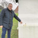 Christoph Wember zeigt auf Flecken am Bildstock von Elmenhorst.