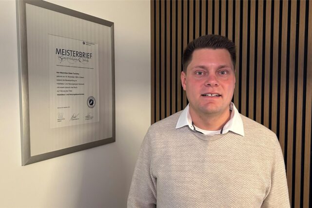 Maximilian Tschirley, Anbieter von „Klo mit Niveau“, steht in seinem Büro in Waltrop neben einem Bilderrahmen mit seinem Meisterbrief.