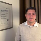 Maximilian Tschirley, Anbieter von „Klo mit Niveau“, steht in seinem Büro in Waltrop neben einem Bilderrahmen mit seinem Meisterbrief.