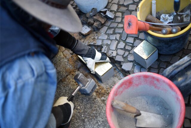 Person verlegt Stolpersteine