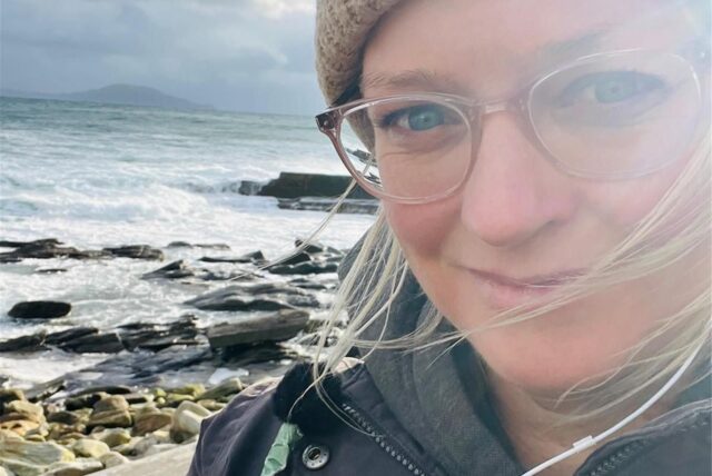 Selfie von Mareike Graepel am Strand mit unruhigem Meer im Hintergrund