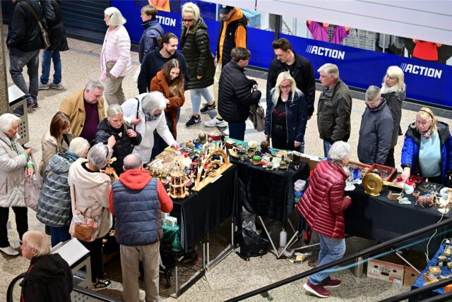 Kunden umlagern einen Stand auf dem Antikmarkt.
