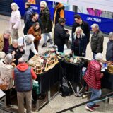Kunden umlagern einen Stand auf dem Antikmarkt.