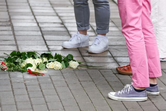 Menschen stehen vor Stolpersteinen