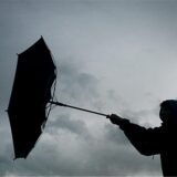 Von einer Windböe erfasst wird der Regenschirm eines Spaziergängers.