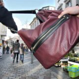 Ein Mann reißt einer Frau die Handtasche vom Arm.