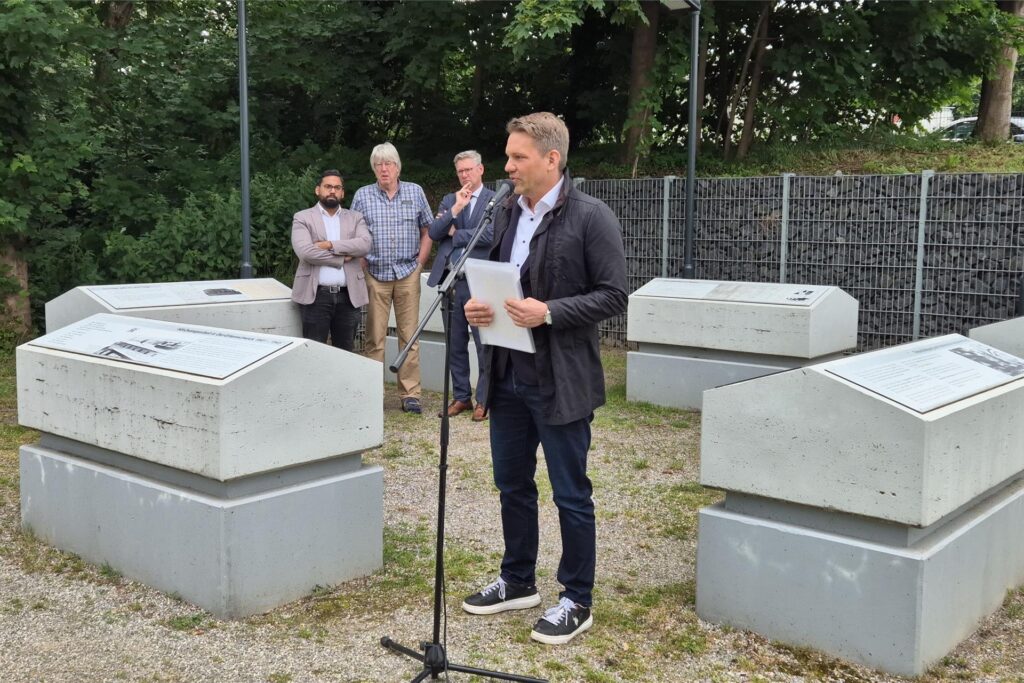 Lehrer Andreas Pleyer, der das Projekt am Willy-Brandt-Gymnasium leitete, trat bei der Einweihung des Zwangsarbeiter-Mahnmals im Mai 2024 in Oer-Erkenschwick ans Mikro. Die Einweihungsrede hielt Bürgermeister Carsten Wewers (2.v.r.). Aufgerufen dazu hatte das Bündnis für Toleranz und Demokratie mit seinen Koordinatoren Shoaiub Nazir (l.) und Josef Oeinck (2.v.l.)