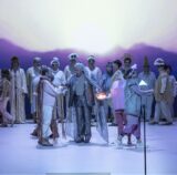 Foto von der Bühne mit Heiko Trinsinger, der sich als messianischer Guru einer bunten Leidensgemeinschaft gibt.