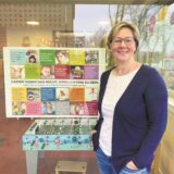 Andrea Wiesmann vor einem Kinderrechte-Plakat an der Kita St. Ludgerus.