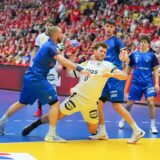Johannes Golla setzt sich im Spiel der Handball-WM 2025 gegen Italien gegen zwei Verteidiger durch.