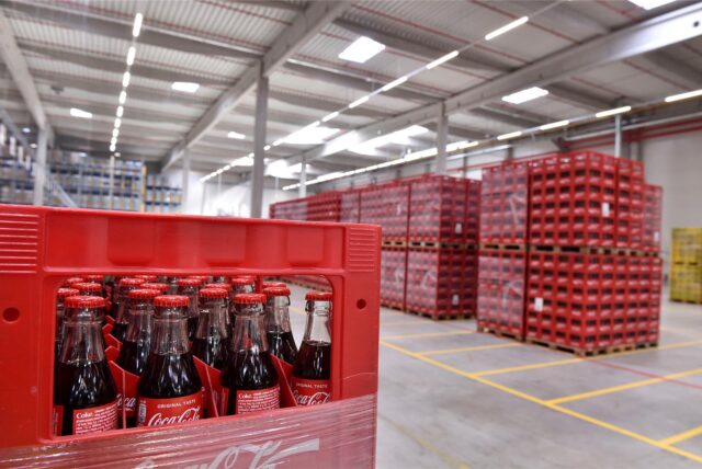 In einer Lagerhalle stehen hunderte Kästen mit Getränken von Coca-Cola.
