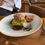 Koch beim Beträufeln eines Hauptgangs mit Sauce.