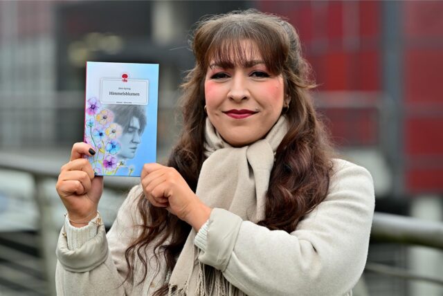 Sandra Schobel hält ihr Buch in die Kamera.