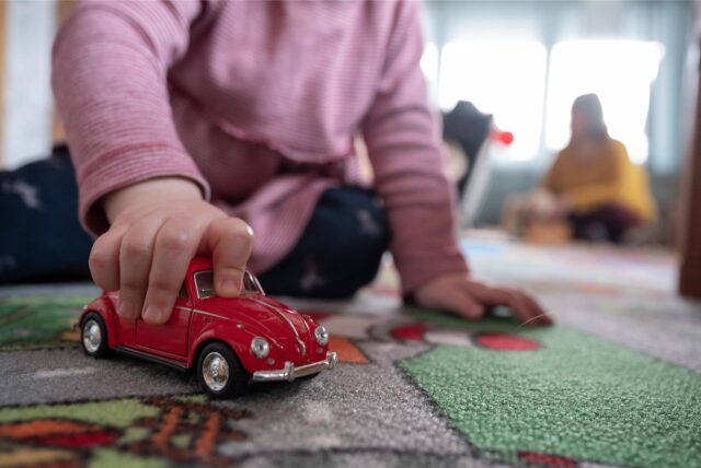 Ein Kind bewegt ein Spielzeugauto.