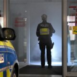 Polizistin steht im Eingang der von Nebel erfüllten Sparkassen-Filiale.