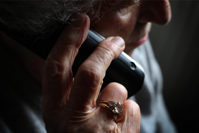 Symbolbild: eine ältere Frau telefoniert mit einem Handy.