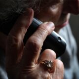 Symbolbild: eine ältere Frau telefoniert mit einem Handy.