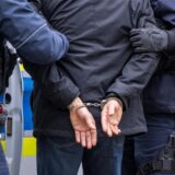 Ein Mann in Handschellen wird von zwei Polizisten abgeführt